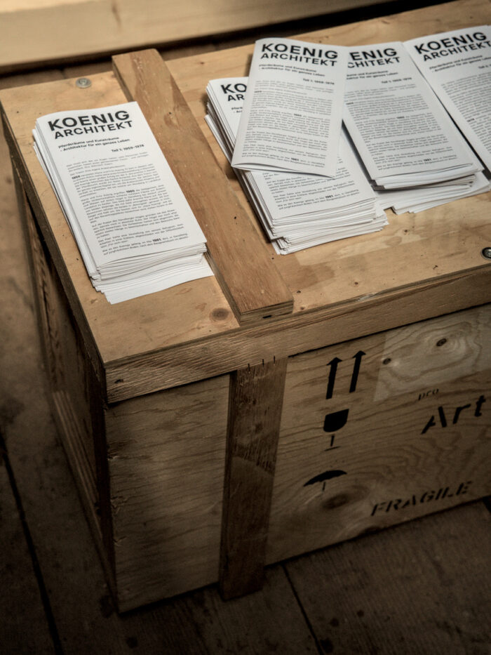 Kiste mit Flyern zur Ausstellung Koenig Architekt im Nebenraum der Kugelhalle am Ganslberg