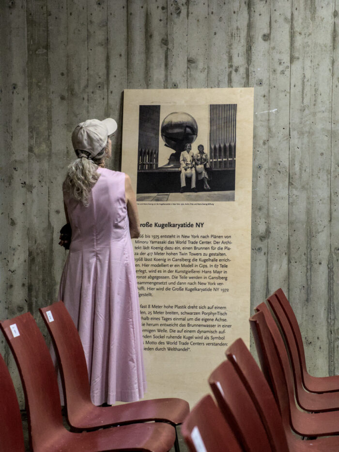 Besucherin betrachtet Ausstellungstafel in der Kugelhalle am Ganslberg
